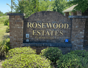 Cordele apartment for rent - a sign for rosewood estates in front of trees and bushes