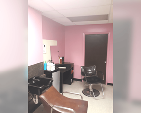 Meridian apartment for rent - a salon room with pink walls and a chair and a sink