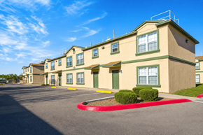 El Paso apartment for rent - A row of beige apartment buildings with green trim and a red circle in the parking lot.