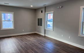 Rockford apartment for rent - an empty living room with wood floors and grey walls