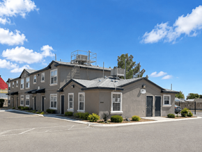 El Paso apartment for rent - A building with a grey roof and a parking lot in front.