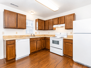 Ashland townhouse for rent - A kitchen with white appliances and wooden cabinets.