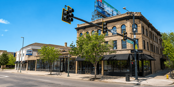 Denver apartment for rent - A street view of a city with a traffic light and a building with a sign that reads "The Standard".