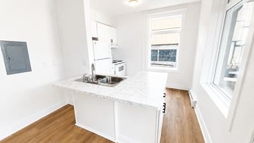 Denver apartment for rent - A kitchen with white cabinets and a window.