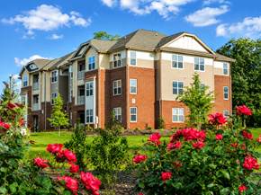 Sanford apartment for rent - A large brick building with a green lawn in front.