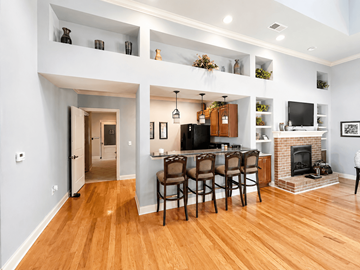 Sanford apartment for rent - A modern living room with a fireplace and a dining table set up.