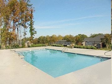 Dalton apartment for rent - A large swimming pool surrounded by trees and a fence.