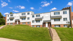 Omaha apartment for rent - A large white building with a red door and windows.