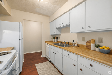 North Little Rock apartment for rent - A kitchen with white cabinets and a wooden counter top.