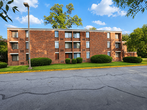 Columbus apartment for rent - A large brick building with a parking lot in front.