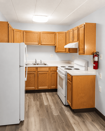 Ypsilanti apartment for rent - A kitchen with wooden cabinets and a white refrigerator.