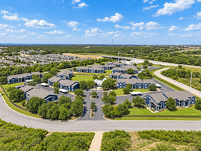 San Marcos townhouse for rent - A large, modern building complex with a parking lot in front.