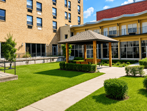 Little Rock apartment for rent - A gazebo is in the middle of a grassy area in front of a tan building.
