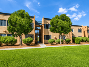 El Paso apartment for rent - A building with a green lawn in front and trees around it.