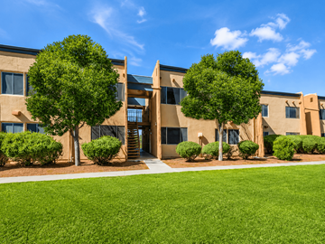 El Paso apartment for rent - A building with a green lawn in front and trees around it.