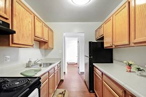 Baltimore apartment for rent - A kitchen with wooden cabinets and a black refrigerator.