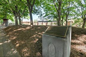 Baltimore apartment for rent - A monument with a plaque on it is surrounded by trees.