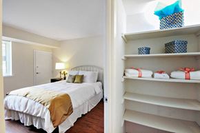 Baltimore apartment for rent - A bedroom with a bed and a closet with shelves.