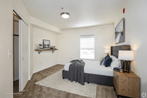 Denver apartment for rent - A bedroom with a bed, nightstand, and a window.