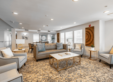 Denver apartment for rent - A living room with a patterned carpet and a large window.