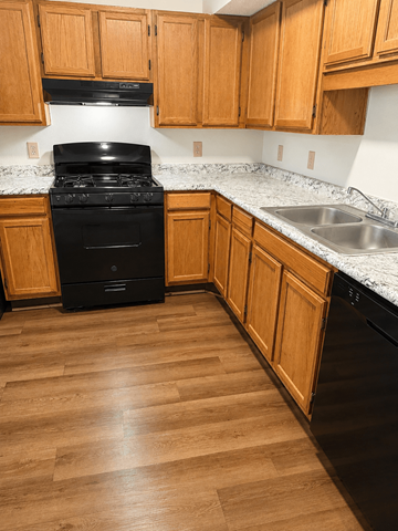 Hebron townhouse for rent - A black stove in a kitchen with wooden cabinets.