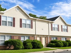 Hebron townhouse for rent - A row of houses with green bushes in front.