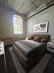 Prattville apartment for rent - A bedroom with a bed, nightstand, and a window with a view of a fence and trees.
