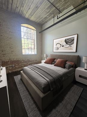 Prattville apartment for rent - A bedroom with a bed, nightstand, and a window with a view of a fence and trees.