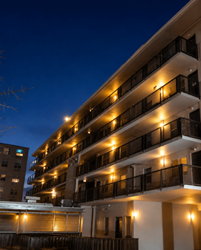 Meridian apartment for rent - A building with balconies lit up at night.
