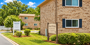 Jacksonville apartment for rent - A sign for Desert Winds Apartments stands in front of a brick building.