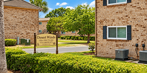 Jacksonville apartment for rent - A sign for Desert Winds Apartments stands in front of a brick building.