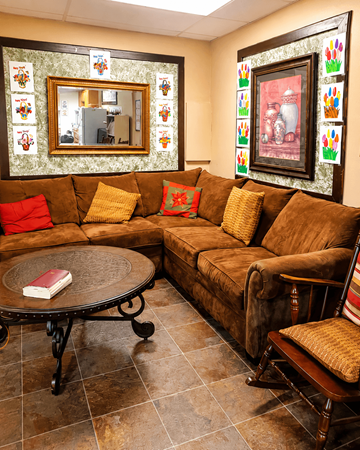 Meridian apartment for rent - A living room with a brown couch, a round table, and a mirror on the wall.