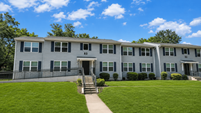 Newnan apartment for rent - A grey building with a black door and windows.