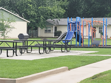 Alexandria apartment for rent - A playground with a blue slide and picnic tables.