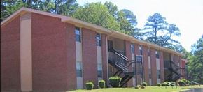 Grenada apartment for rent - a large brick building with a staircase in front of it