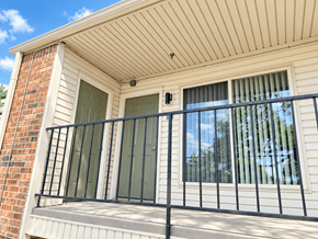 The Woodlands apartment for rent - A balcony with a black railing and a window with a view of trees.