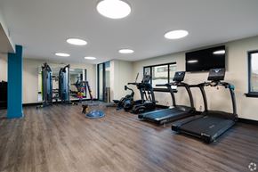 St. Louis apartment for rent - A gym with treadmills, weights, and a television.