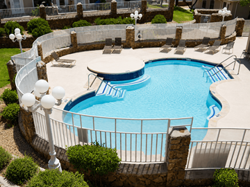 El Paso townhouse for rent - A round swimming pool surrounded by a fence and a stone wall.