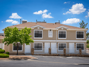 El Paso townhouse for rent - A beige two-story house with a white fence and a tree in front.