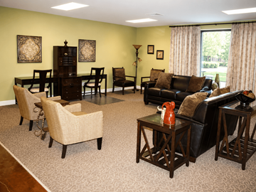 New Orleans apartment for rent - A living room with a black couch, a coffee table, and a dining table with chairs.