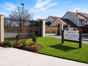 New Orleans apartment for rent - A sign for Garden Oaks Tower is in front of a black gate.