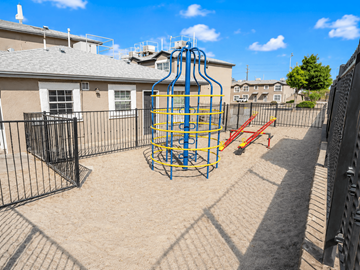 El Paso apartment for rent - A playground with a blue and yellow structure and a red slide.