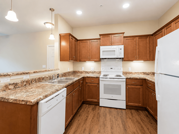 Nashville apartment for rent - A kitchen with brown cabinets and white appliances.