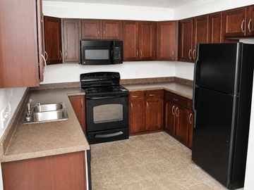 Montgomery apartment for rent - A kitchen with black appliances and wooden cabinets.