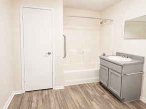 El Paso apartment for rent - A white door is open to a bathroom with a sink and a wooden floor.