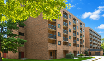 Hopewell townhouse for rent - A large brick building with balconies and a tree in front.