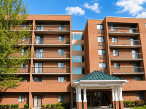 Hopewell townhouse for rent - A large brick building with a green roof and a covered walkway entrance.