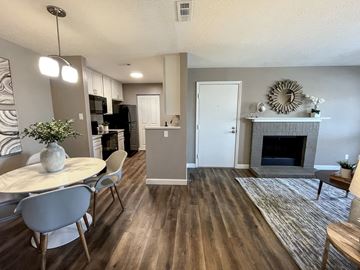 St Peters apartment for rent - an open living room and dining room with a fireplace and a table
