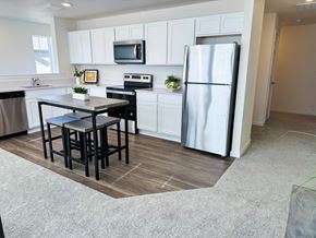 Denver apartment for rent - a kitchen with white cabinets and a stainless steel refrigerator