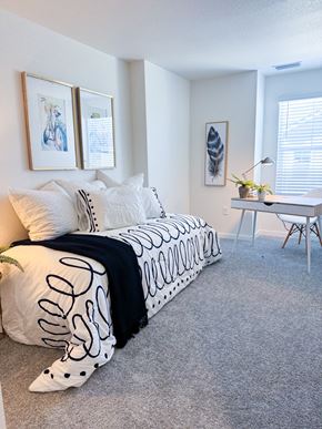 Denver apartment for rent - a bedroom with a bed with black and white pillows and a desk